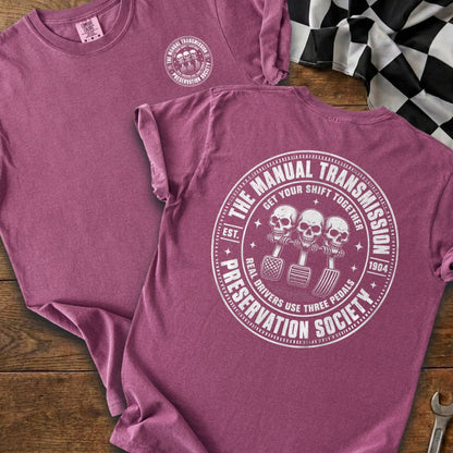 Maroon t-shirt with "Manual Transmission Preservation Society" logo featuring skulls and pedals.