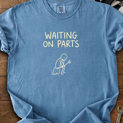 Blue shirt with "WAITING ON PARTS" text and a stick figure holding a bolt.