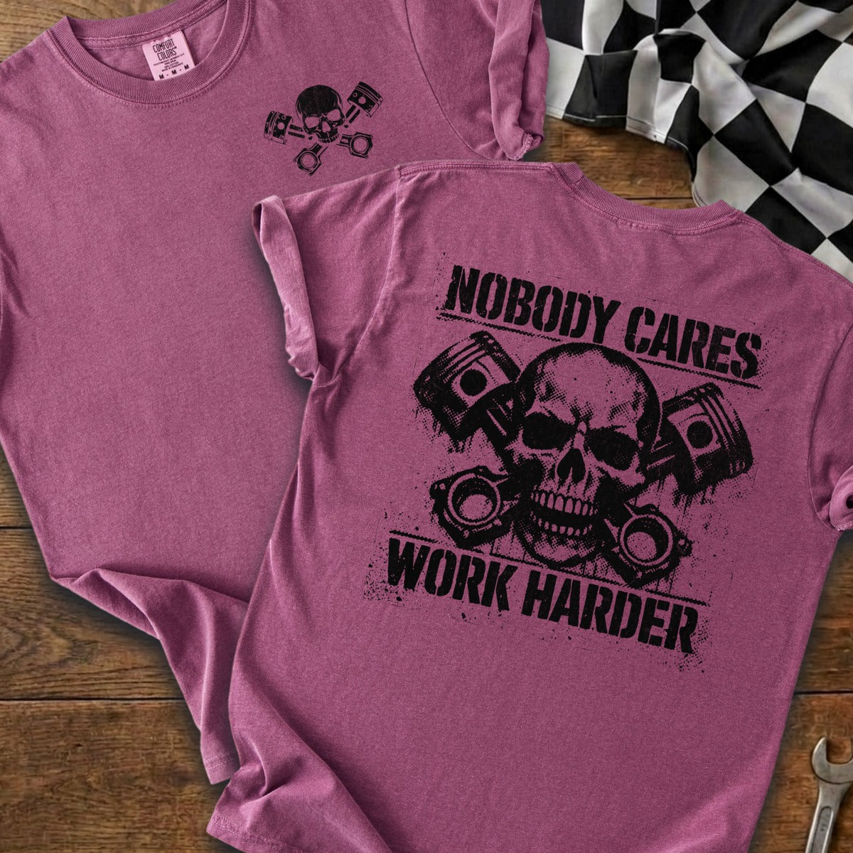 Maroon t-shirt with skull and pistons graphic and text "NOBODY CARES WORK HARDER".