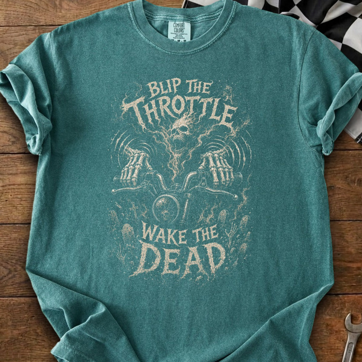 Teal t-shirt with skeleton hands on motorcycle and text "Blip the Throttle Wake the Dead".