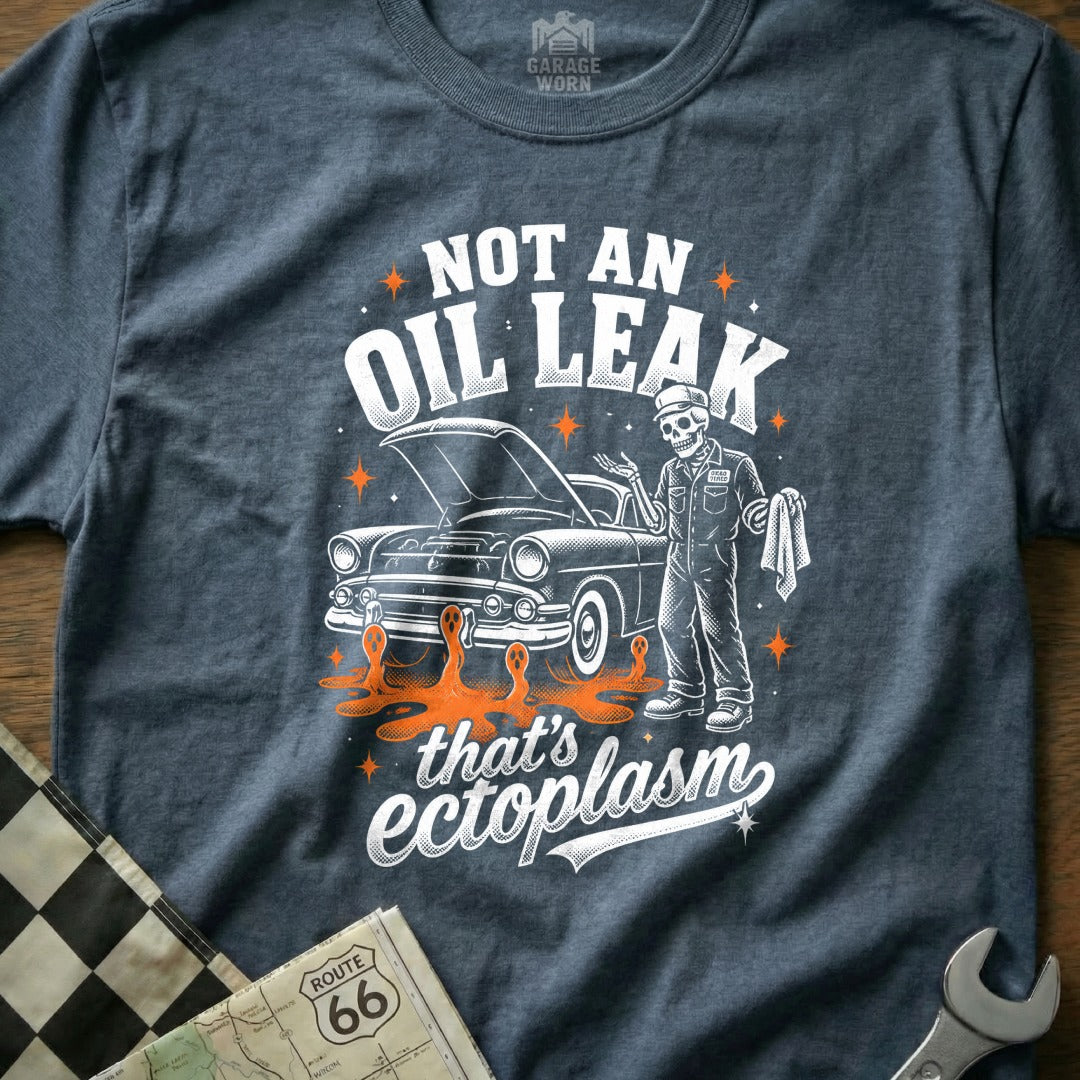 Not an oil leak, that's ectoplasm text on a dark shirt with a skeleton mechanic and vintage car.