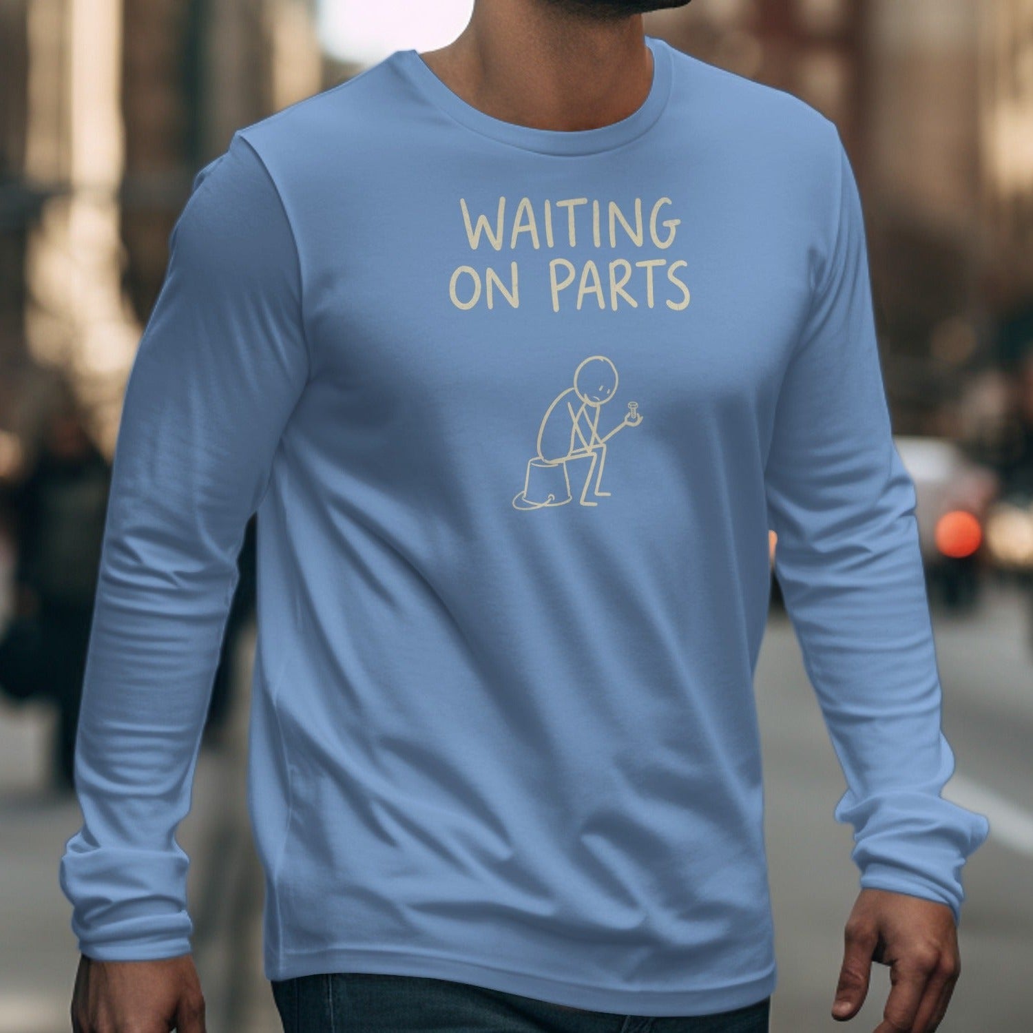 Light blue long-sleeve shirt with "WAITING ON PARTS" text and stick figure holding a screw.