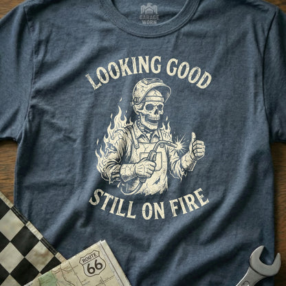 Skeleton welder giving thumbs up with "Looking Good Still On Fire" text.