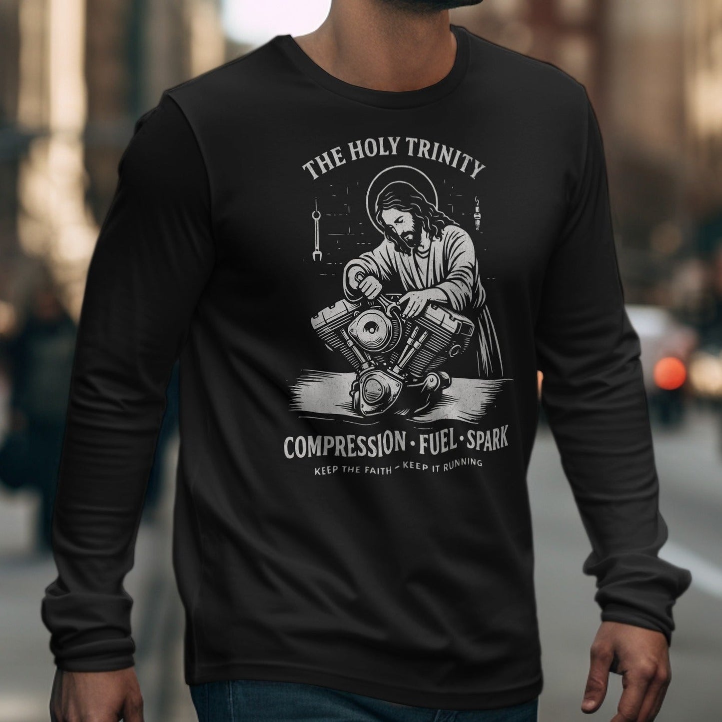 Black long-sleeve shirt with graphic of Jesus working on a motorcycle engine and text.