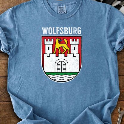 Wolfsburg crest with text above, featuring a yellow dog over a castle emblem.