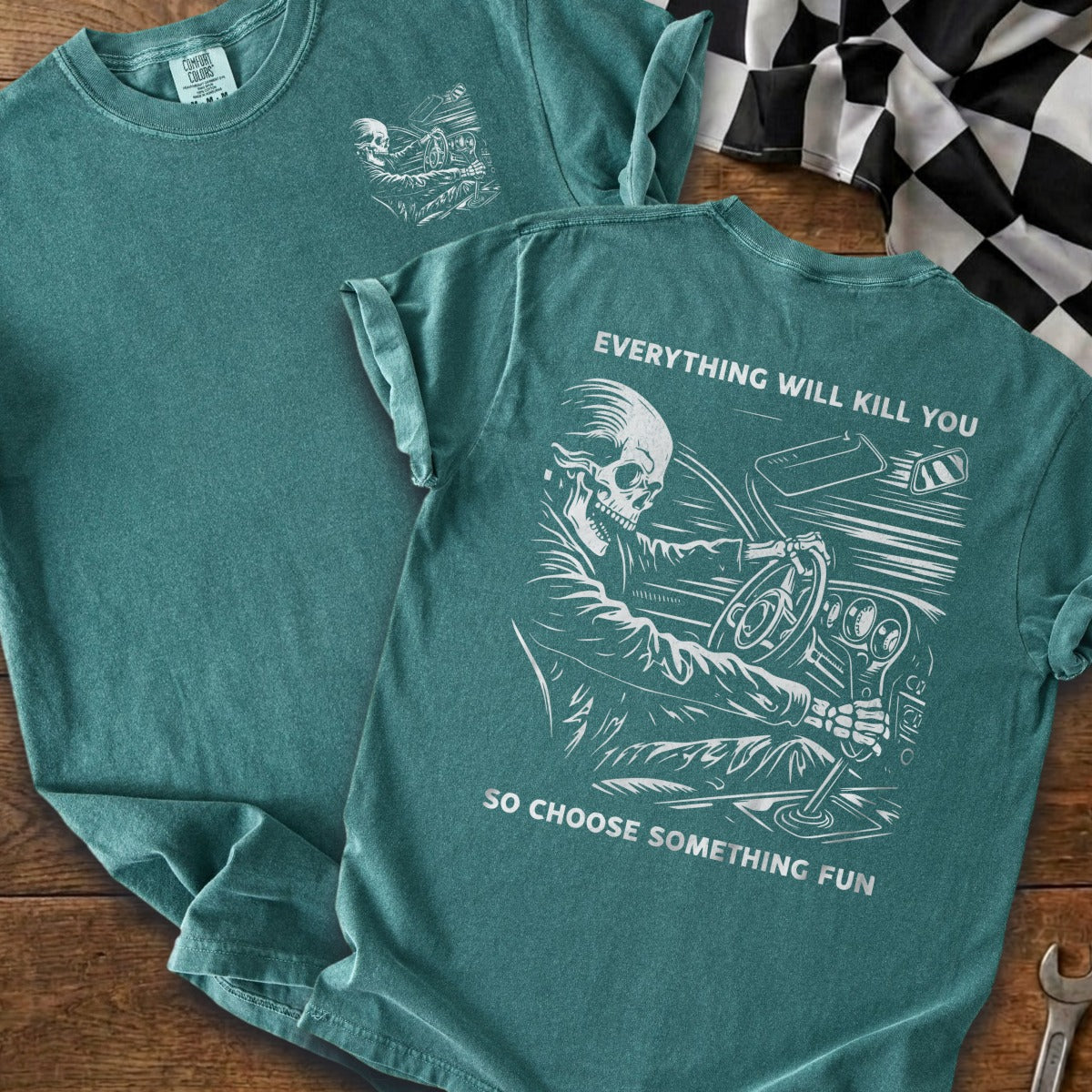 T-shirt graphic of skeleton driving car with text "EVERYTHING WILL KILL YOU SO CHOOSE SOMETHING FUN".