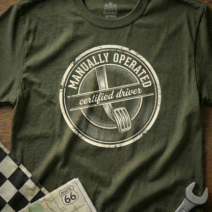 T-shirt with "Manually Operated Certified Driver" stamp and clutch pedal graphic.