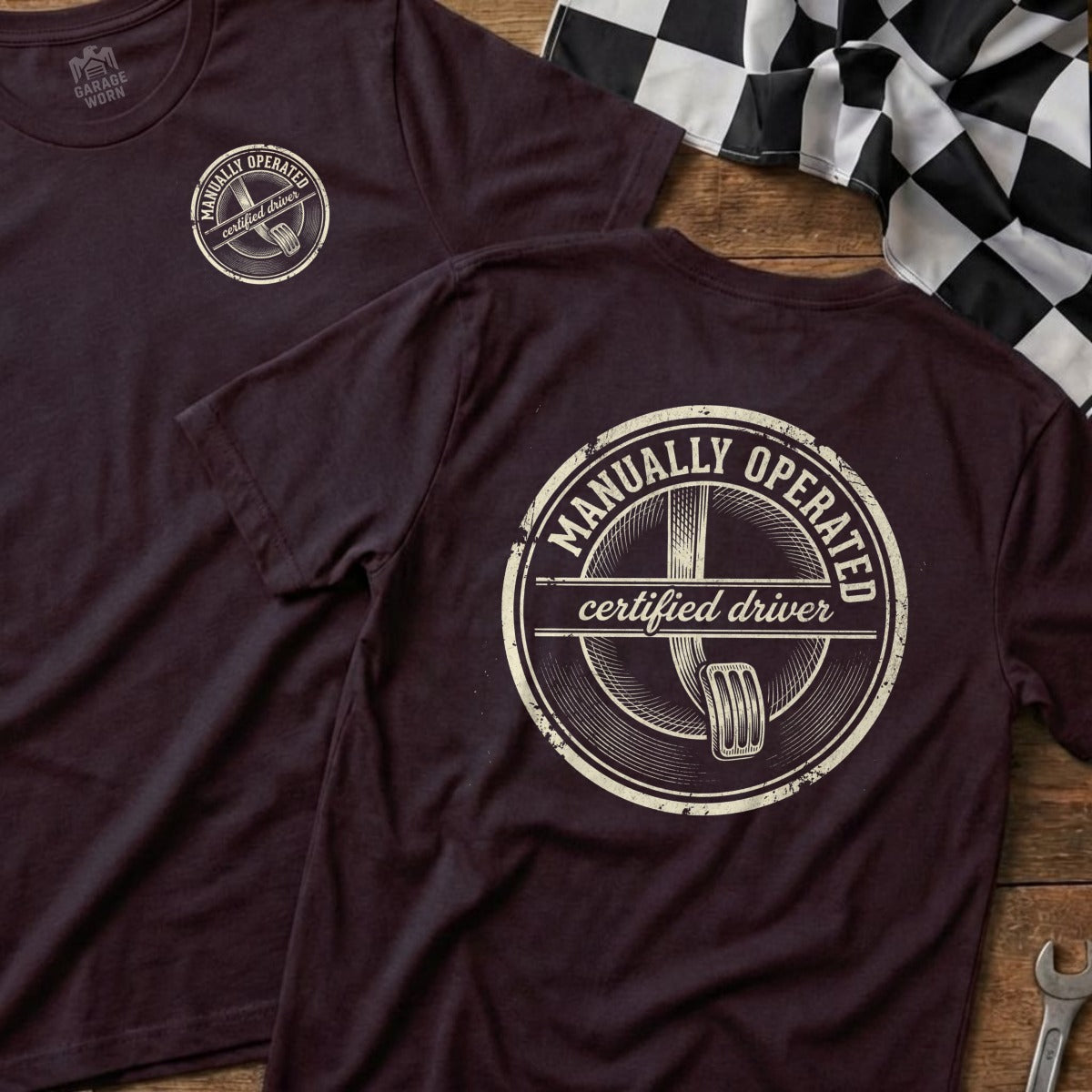 T-shirt with "Manually Operated Certified Driver" logo on dark fabric.
