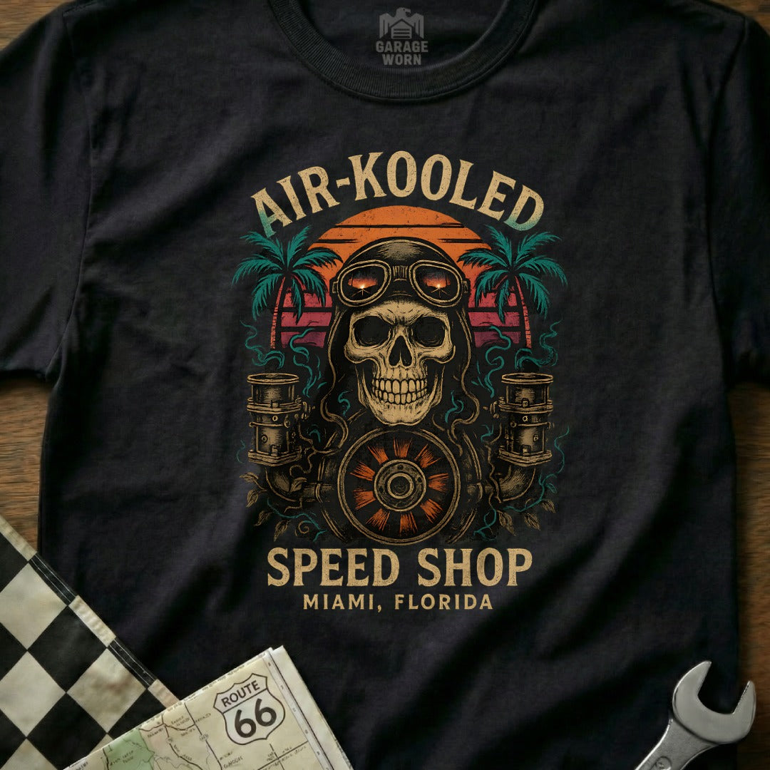 Skull with goggles and pipes, "Air-Kooled Speed Shop" text, palm trees, sunset.