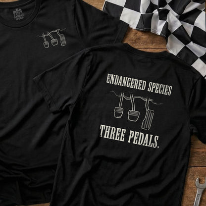 Black t-shirts with "Endangered Species Three Pedals" graphic featuring car pedals.