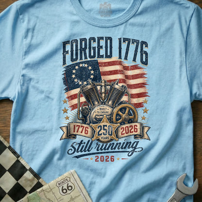 Light blue t-shirt with "Forged 1776" graphic featuring a motorcycle engine and US flag.