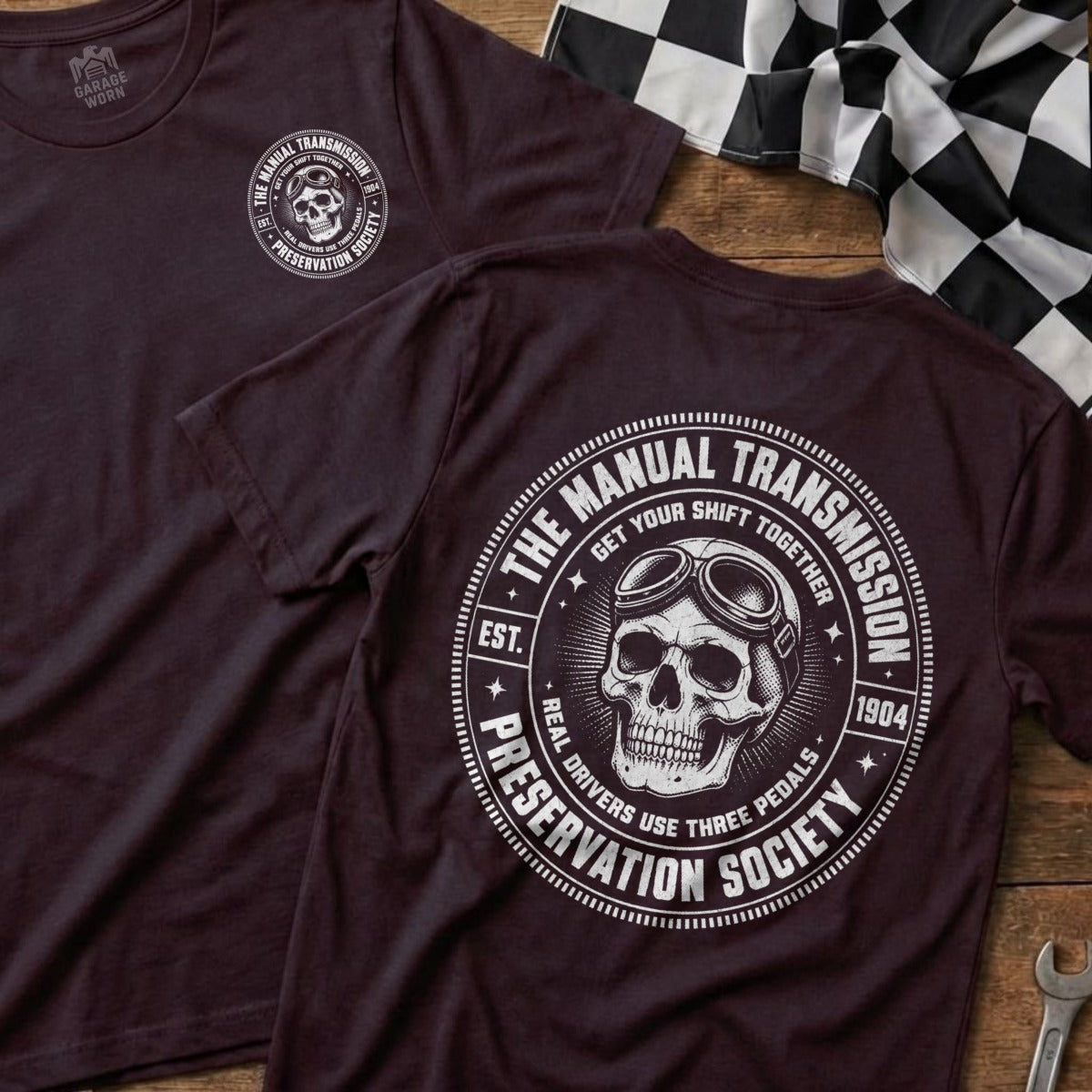 Dark t-shirt with circular graphic featuring a skull with goggles, "Manual Transmission Preservation Society" text.