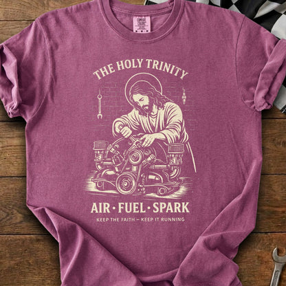 Jesus working on an engine reads "The Holy Trinity Air Fuel Spark".