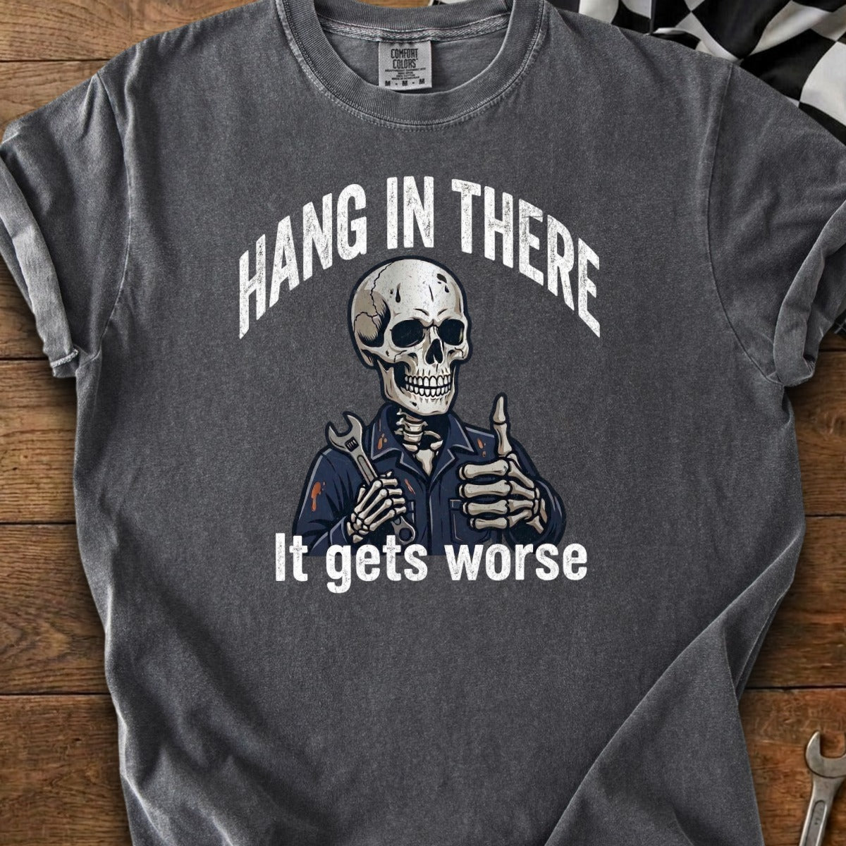 Skeleton wearing overalls holds wrench and gives thumbs up, text "Hang in there" and "It gets worse."