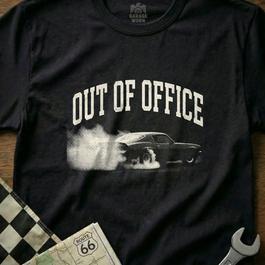Black t-shirt with white "Out of Office" text and a smoking car graphic.