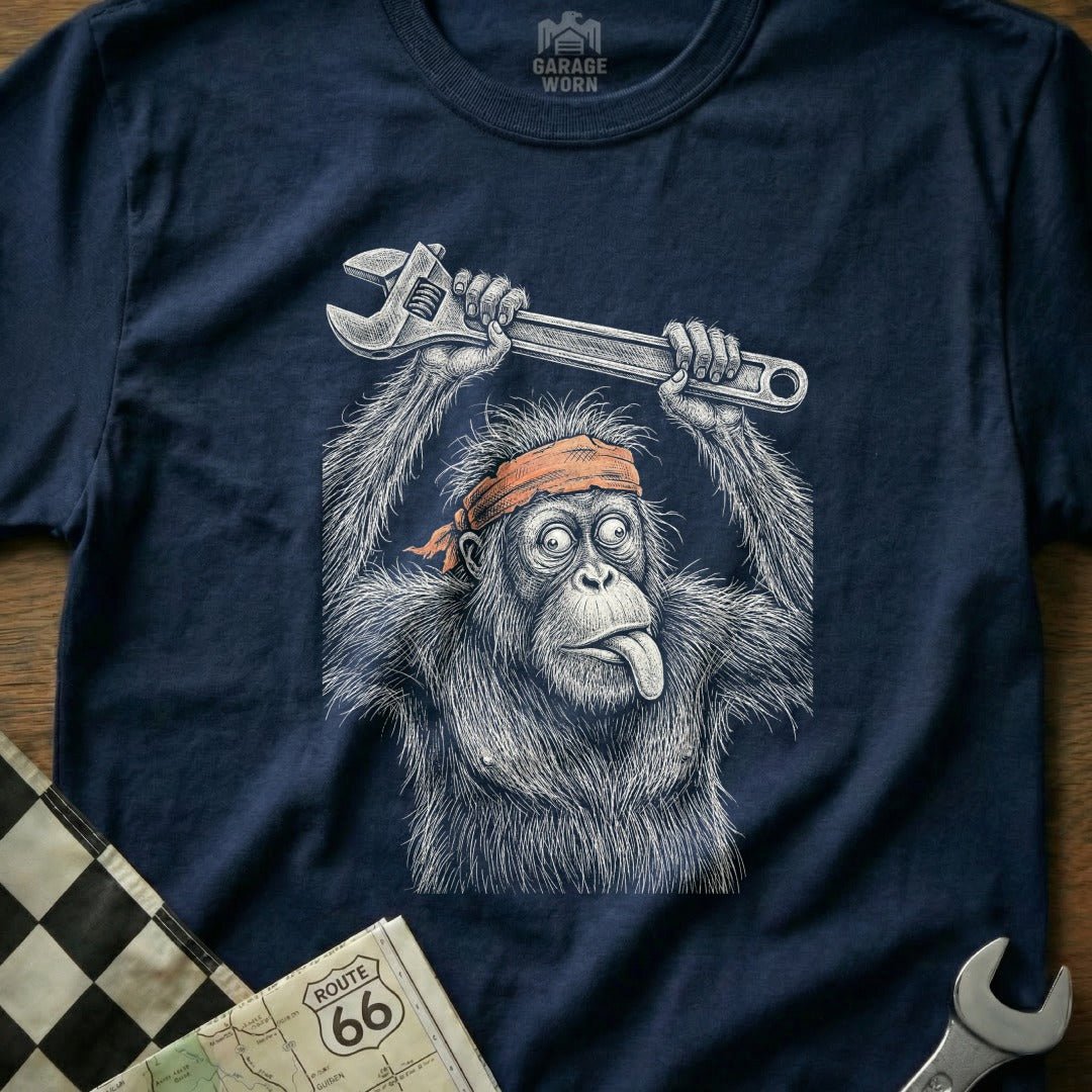 Orangutan with wrench on head, tongue out, orange bandana, garage worn logo.