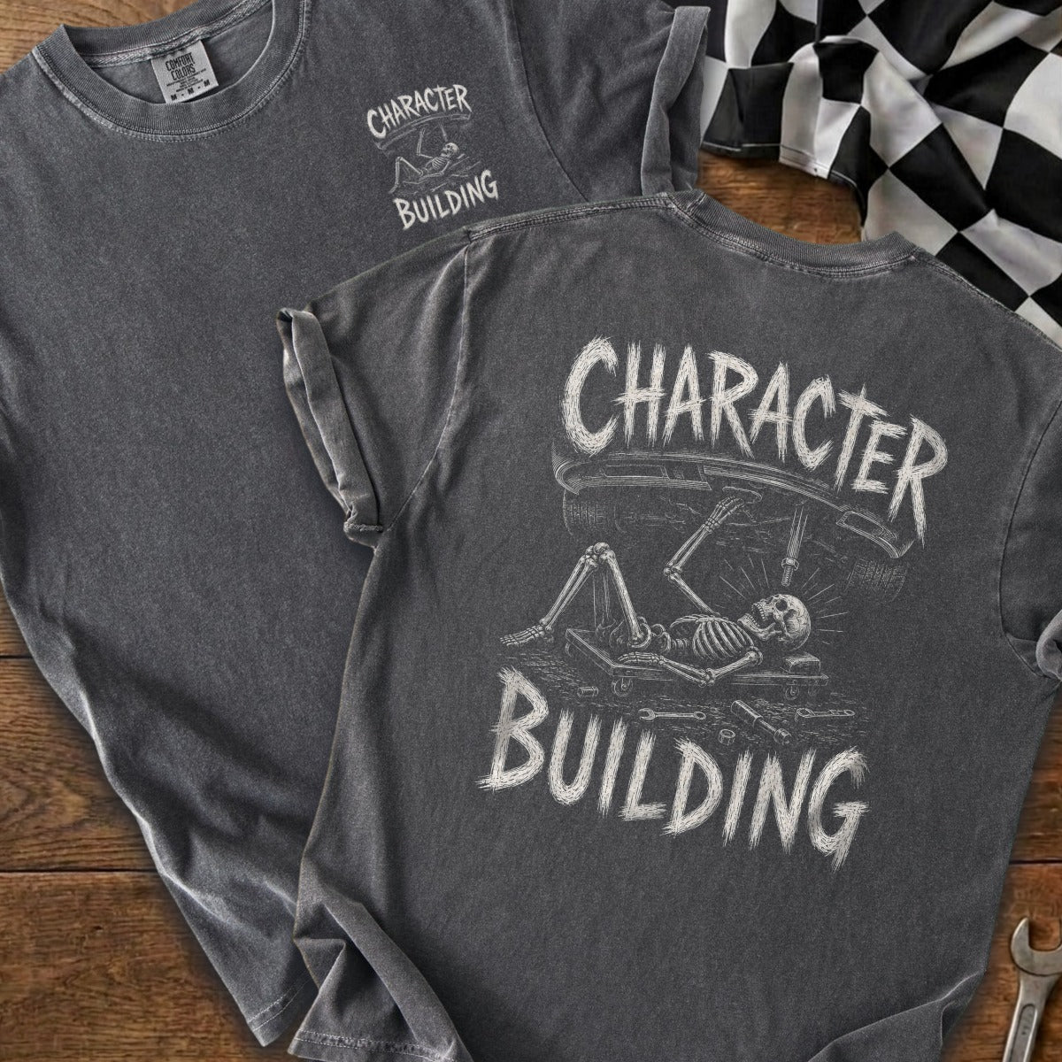 Dark gray t-shirt with a skeleton working on a car, the words "CHARACTER BUILDING" above and below.