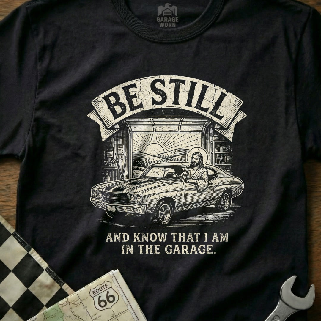 T-shirt with Jesus in a muscle car and text "Be Still and Know That I Am in the Garage."