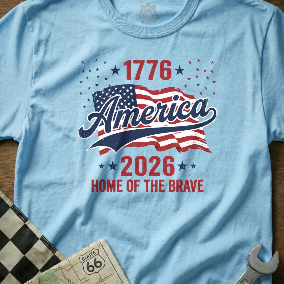 Light blue t-shirt with "America 1776-2026 Home of the Brave" and American flag.