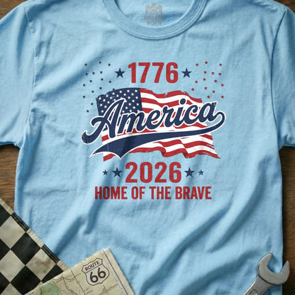 Light blue t-shirt with "America 1776-2026 Home of the Brave" and American flag.