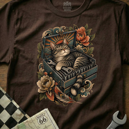 Tabby cat rests in an open toolbox with wrenches and socket set amid floral art.
