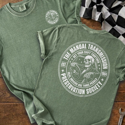 Green t-shirt with skeleton driving and text "The Manual Transmission Preservation Society".