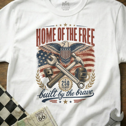 White t-shirt with "HOME OF THE FREE built by the brave" and patriotic eagle graphic.