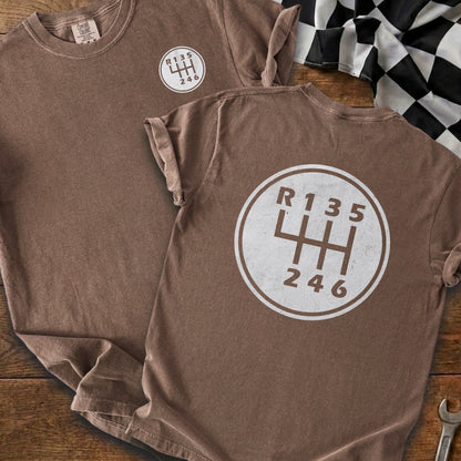 Brown t-shirts feature a white circular graphic of a manual gear shift pattern.