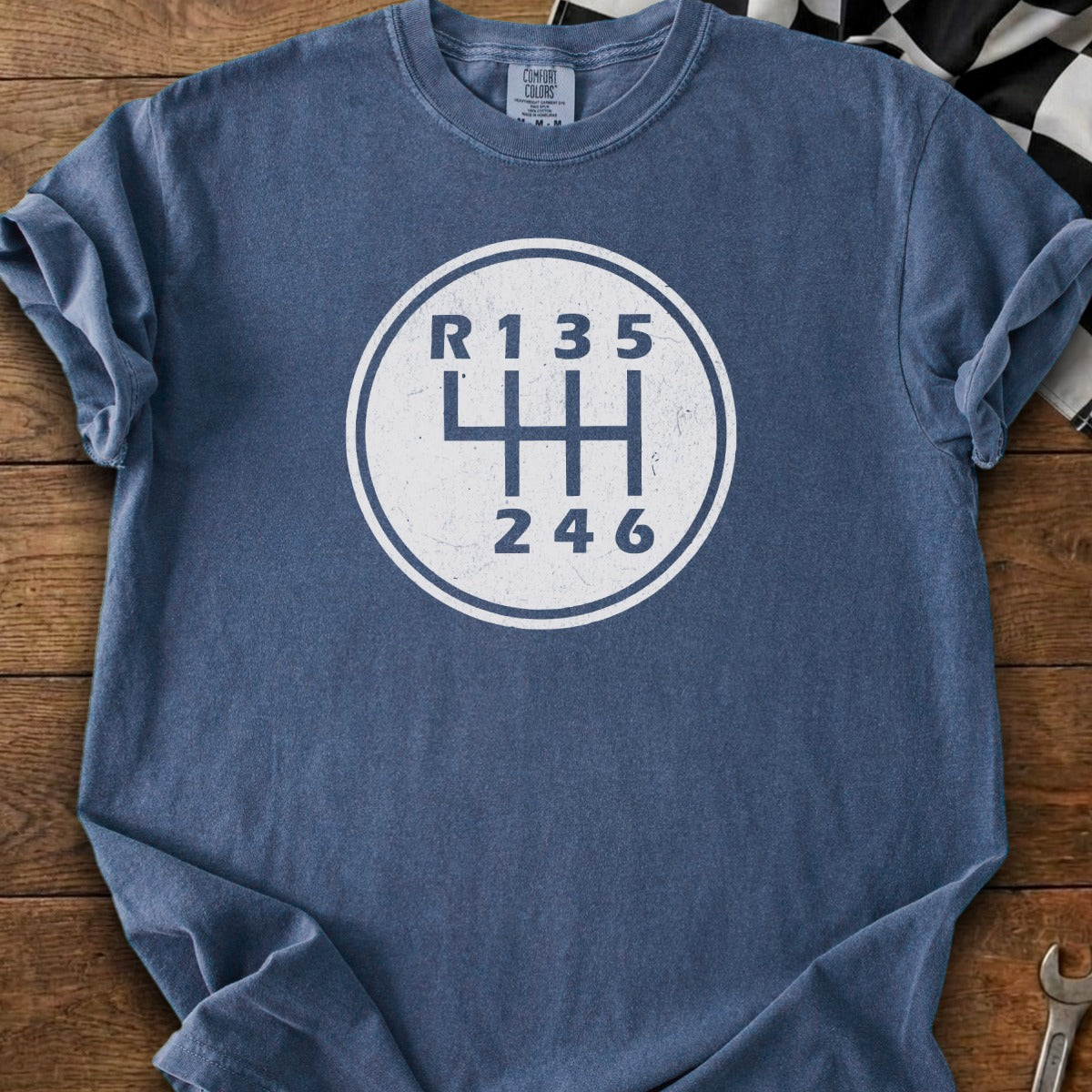 Blue t-shirt with white six-speed manual transmission shift pattern graphic.
