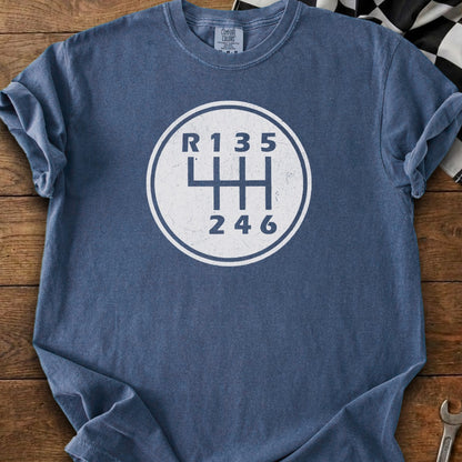 Blue t-shirt with white six-speed manual transmission shift pattern graphic.