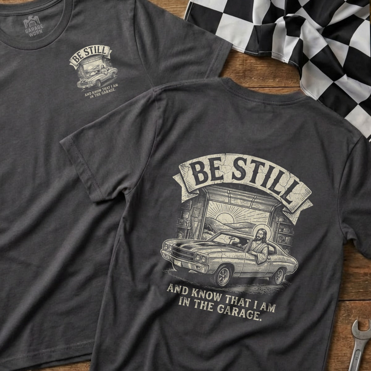 T-shirt with "Be Still and Know That I Am In The Garage" text and graphic.