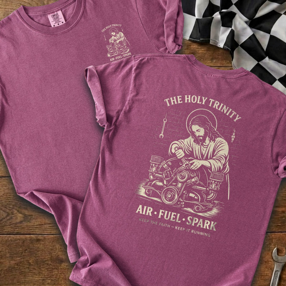 Pink t-shirt featuring "The Holy Trinity" graphic of Jesus with an engine and "Air Fuel Spark."