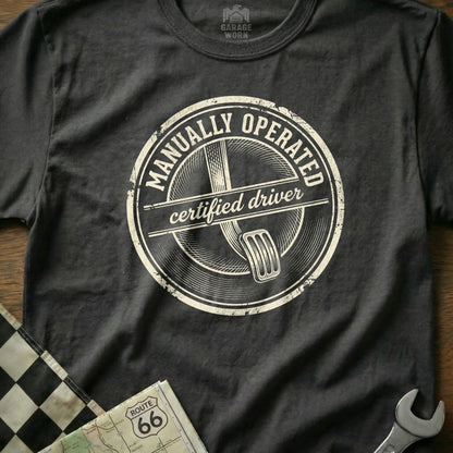 T-shirt with "MANUALLY OPERATED certified driver" circular graphic.
