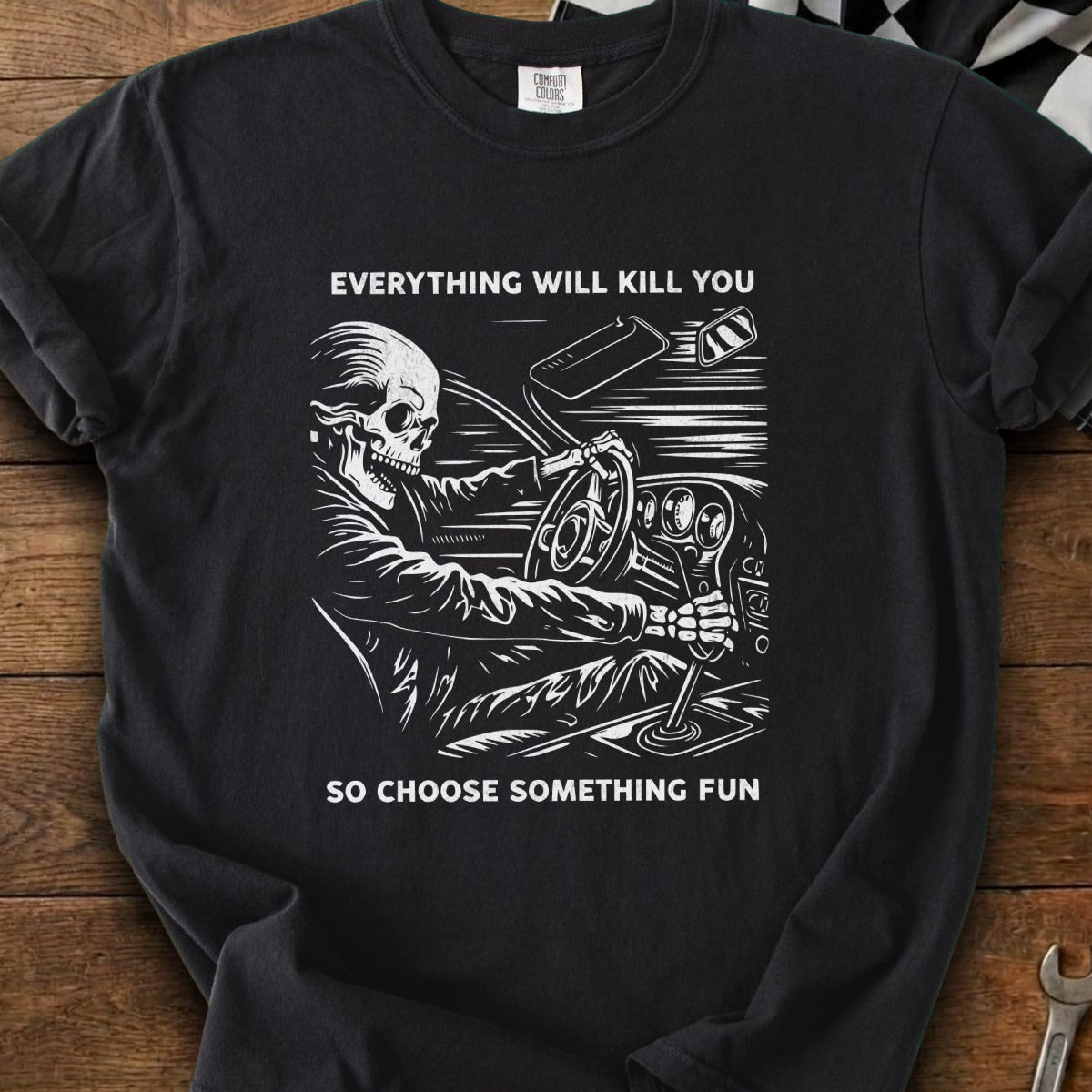 T-shirt with skeleton driving car and text "Everything will kill you, so choose something fun."