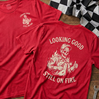 Red t-shirt with skeleton welder graphic and "Looking Good Still On Fire" text.