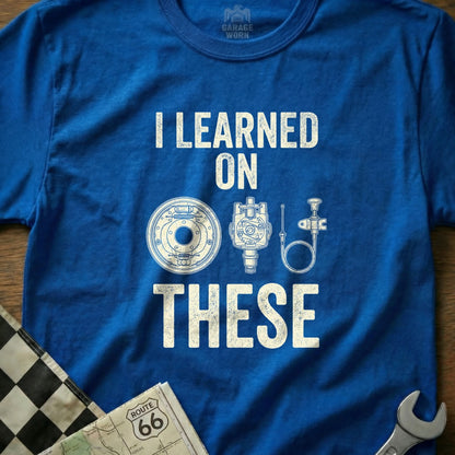Blue t-shirt with "I LEARNED ON THESE" and automotive parts graphic.