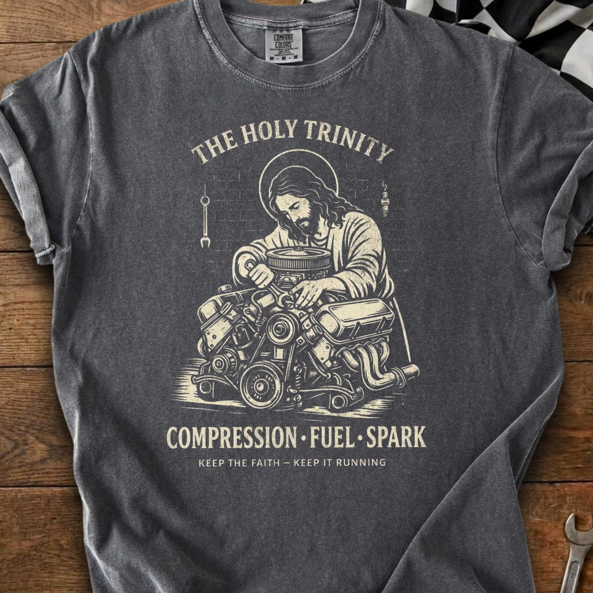 Jesus working on an engine with text "The Holy Trinity Compression Fuel Spark".