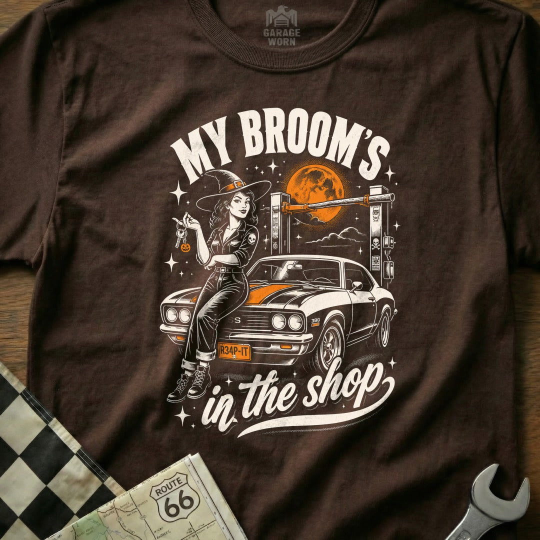 Witch in witch hat leans on muscle car, text "My Broom's in the shop".