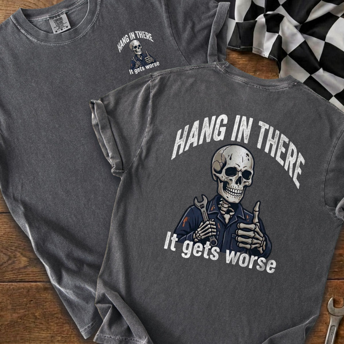 Dark gray t-shirt with skeleton holding wrench and thumbs up, "Hang in there, it gets worse."