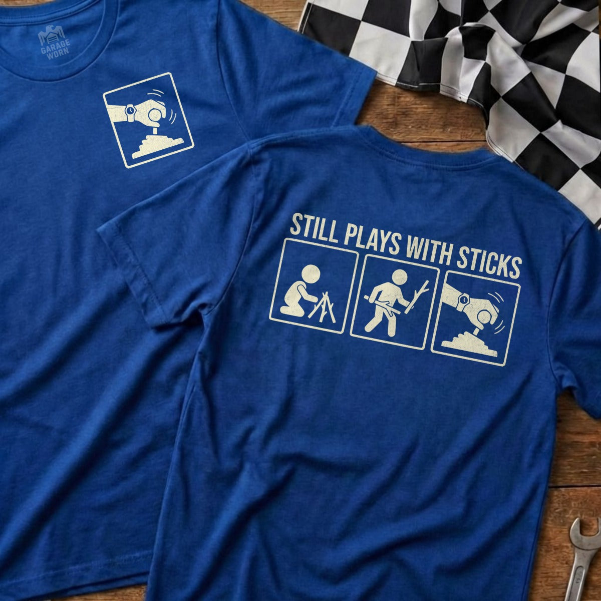 Blue t-shirt with "STILL PLAYS WITH STICKS" and cartoon stick figures.