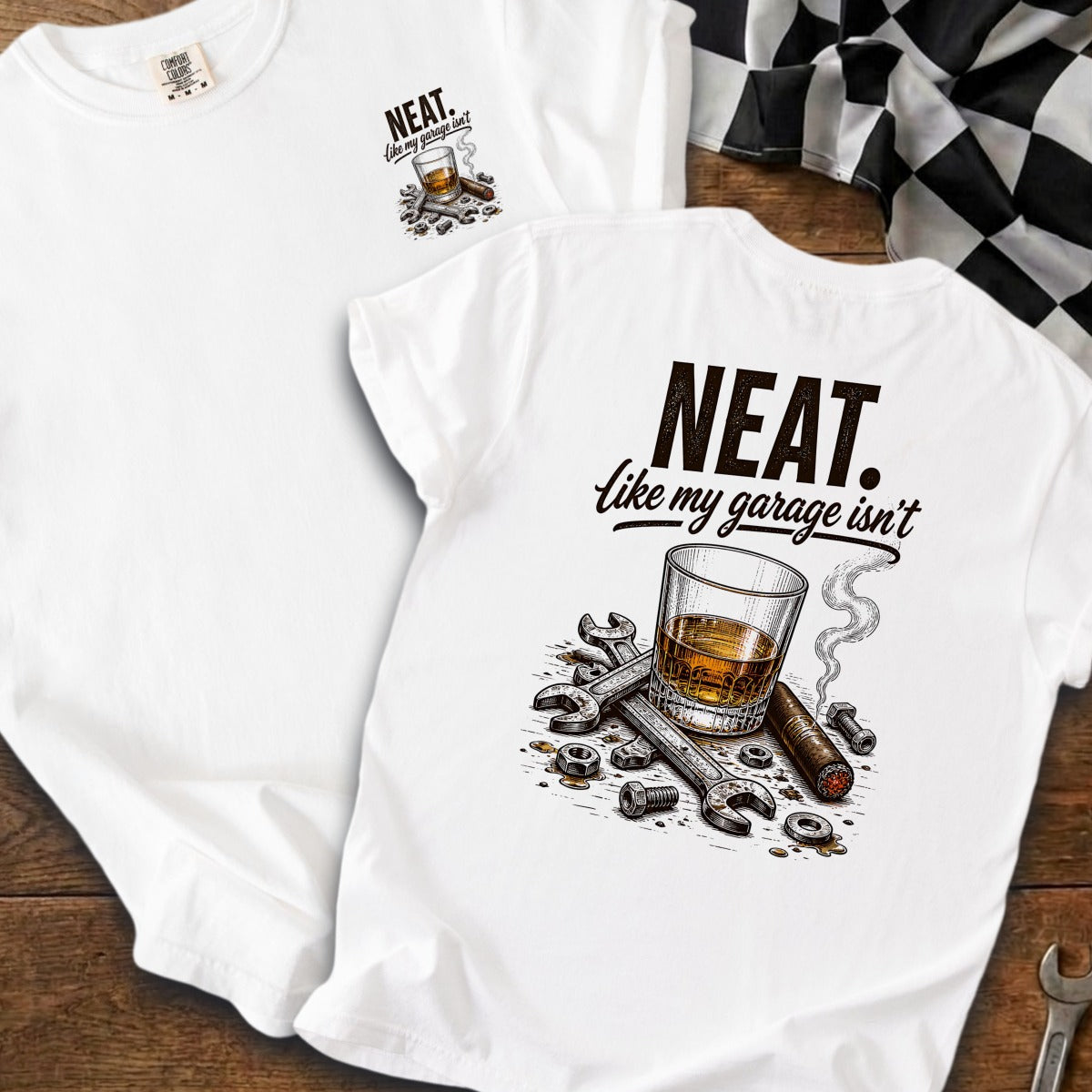 White t-shirt with graphic of whiskey, cigar, and tools reading "NEAT. like my garage isn't".