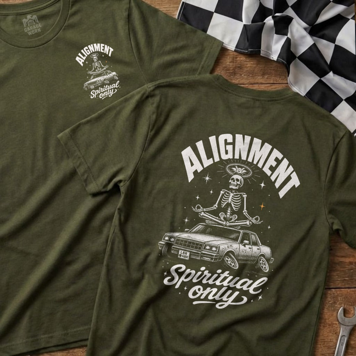 Olive green t-shirt with "Alignment Spiritual only" graphic of skeleton meditating on a car.