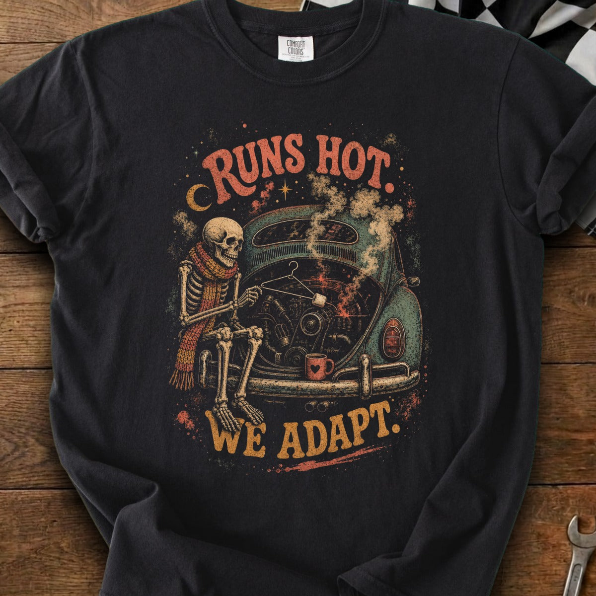 Skeleton in scarf repairs car engine with marshmallow on stick. "Runs Hot. We Adapt."