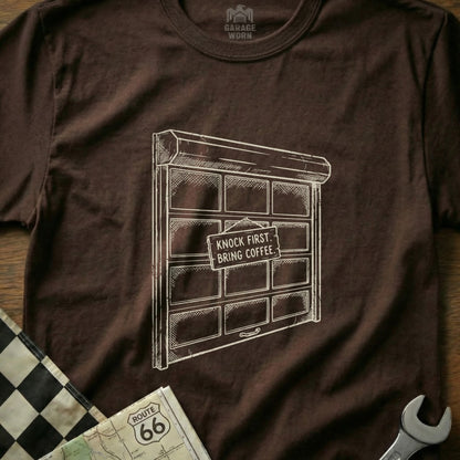 Brown t-shirt with sketch of a garage door that says "Knock first. Bring coffee."