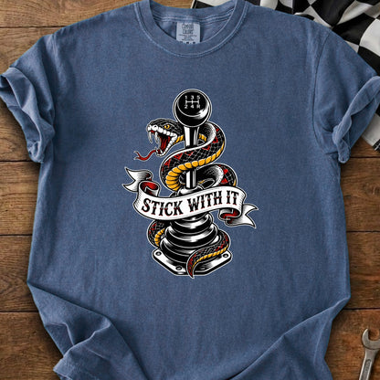 T-shirt with snake wrapped around a manual transmission shift knob, banner reads "Stick With It".