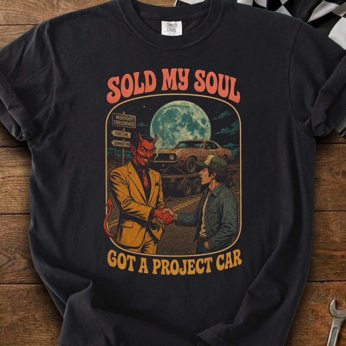 Devil in suit shakes man's hand by car trailer under moon. Text: Sold My Soul, Got A Project Car.