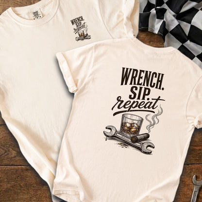 Cream t-shirt with "WRENCH. SIP. repeat." text, glass, cigar, and wrenches graphic.