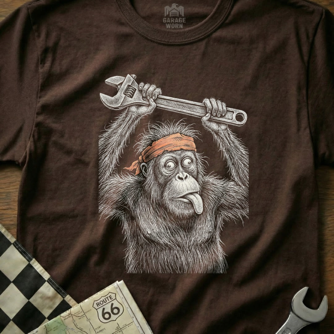 Orangutan wearing an orange headband, holding a wrench above head, tongue sticking out.