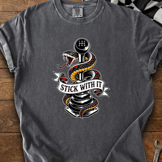 Snake coiled around a manual shift knob with "STICK WITH IT" banner.