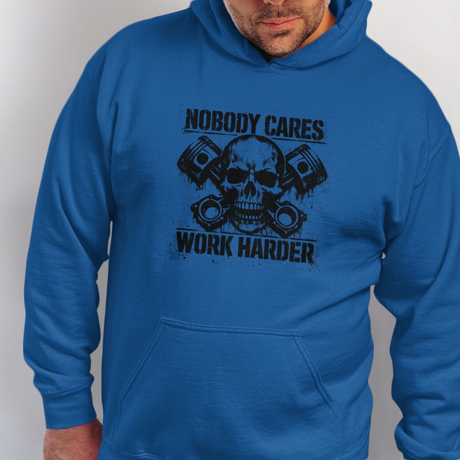 Blue hoodie with a black graphic of a skull, pistons, and text "NOBODY CARES WORK HARDER".